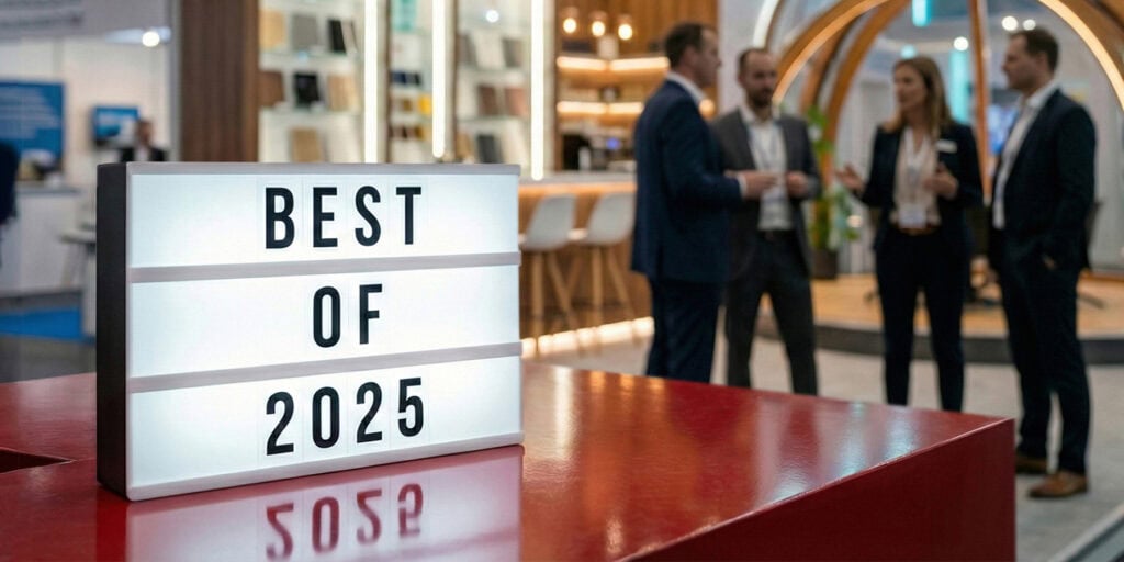 Ein hochwertiger Messestand mit Personen, vor dem eine Light-Box steht mit dem Text: „Best of 2025“